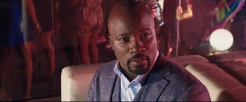 Movie still from “Girls Trip” (2017), directed by Malcolm D. Lee – A person wearing a suit and tie; Close Up shot, Over the shoulder angle