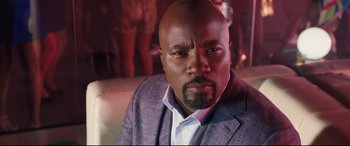 Movie still from “Girls Trip” (2017), directed by Malcolm D. Lee – A person wearing a suit and tie; Close Up shot, Low angle