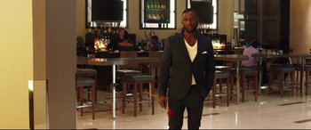 Movie still from “Girls Trip” (2017), directed by Malcolm D. Lee – A man in a suit holding a red rose in his hand; Medium shot, Over the shoulder angle