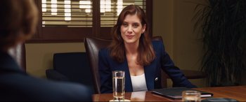 Movie still from “Girls Trip” (2017), directed by Malcolm D. Lee – A woman sitting at a table with a glass of water in front of her; Medium shot, Over the shoulder angle