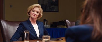 Movie still from “Girls Trip” (2017), directed by Malcolm D. Lee – A woman sitting at a table in front of a glass of water; Medium shot, Over the shoulder angle