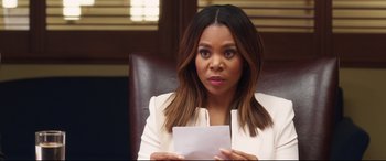 Movie still from “Girls Trip” (2017), directed by Malcolm D. Lee – A woman sitting in a chair holding a piece of paper; Close Up shot, Over the shoulder angle