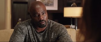 Movie still from “Girls Trip” (2017), directed by Malcolm D. Lee – A man sitting in front of a lamp in a living room; Close Up shot, Over the shoulder angle