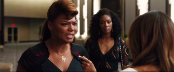 Movie still from “Girls Trip” (2017), directed by Malcolm D. Lee – Two women are standing together and one of them is holding a cigarette; Close Up shot, Over the shoulder angle