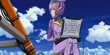 Movie still from “Evangelion: 3.0+1.01 Thrice Upon a Time” (2021), directed by Joe Fria – A woman in a purple suit holding a laptop; Medium shot, Low angle