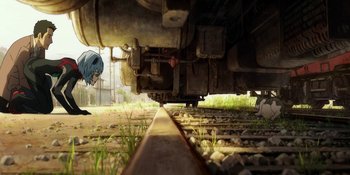 Movie still from “Evangelion: 3.0+1.01 Thrice Upon a Time” (2021), directed by Joe Fria – A person standing next to a train on a train track; Wide shot, High angle