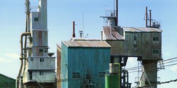 Movie still from “Evangelion: 3.0+1.01 Thrice Upon a Time” (2021), directed by Joe Fria – An industrial area with buildings and a tower; Extreme Wide shot, Low angle