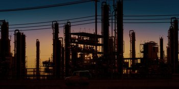 Movie still from “Evangelion: 3.0+1.01 Thrice Upon a Time” (2021), directed by Joe Fria – An oil refinery at sunset with a car parked in front of it; Extreme Wide shot, Low angle