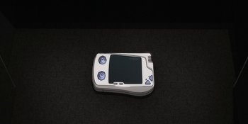 An electronic device is sitting on a black surface