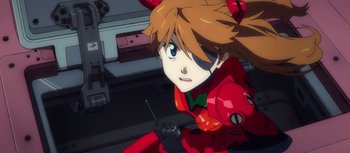 Movie still from “Evangelion: 3.0 You Can (Not) Redo” (2012), directed by Kiyotaka Suzuki – A woman in a red suit is sitting down; Close Up shot, Low angle
