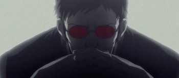 Movie still from “Evangelion: 3.0 You Can (Not) Redo” (2012), directed by Kiyotaka Suzuki – A man with red glasses is sitting in front of a wall; Close Up shot, Low angle