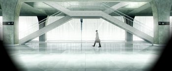 Movie still from “Everly” (2014), directed by Joe Lynch – A man is walking in a white building; Extreme Wide shot, Low angle