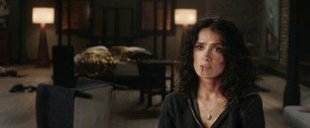 Movie still from “Everly” (2014), directed by Joe Lynch – A woman in a black shirt with a knife in her mouth; Close Up shot, Over the shoulder angle
