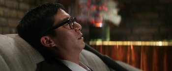 Movie still from “Everly” (2014), directed by Joe Lynch – A person wearing a suit and glasses; Close Up shot, Low angle