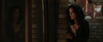 Movie still from “Everly” (2014), directed by Joe Lynch – A woman standing next to a brick wall with her mouth open; Medium shot, Over the shoulder angle