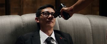 Movie still from “Everly” (2014), directed by Joe Lynch – A man wearing a suit and tie holding a handgun up to his eye; Close Up shot, Over the shoulder angle