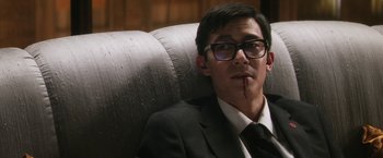 Movie still from “Everly” (2014), directed by Joe Lynch – A man sitting in a chair wearing a suit and glasses; Close Up shot, High angle