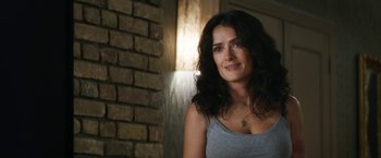 Movie still from “Everly” (2014), directed by Joe Lynch – A woman with long black curly hair wearing a gray tank top; Close Up shot, Over the shoulder angle