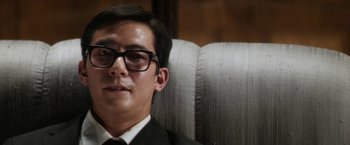 Movie still from “Everly” (2014), directed by Joe Lynch – A young man wearing a suit and tie; Close Up shot, Low angle