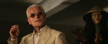 Movie still from “Everly” (2014), directed by Joe Lynch – An older man in a white suit and sunglasses; Close Up shot, Low angle
