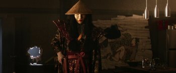 Movie still from “Everly” (2014), directed by Joe Lynch – A woman in a hat and robe holding a sword; Medium shot, Low angle