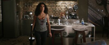 Movie still from “Everly” (2014), directed by Joe Lynch – A woman walking in a kitchen next to a sink; Wide shot, High angle