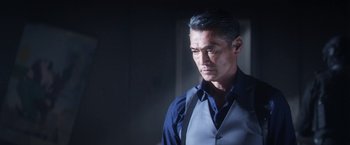 Movie still from “Everly” (2014), directed by Joe Lynch – A person wearing a suit and tie; Close Up shot, Over the shoulder angle