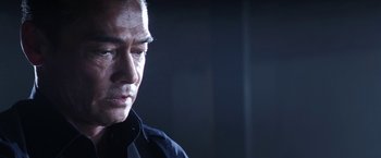 Movie still from “Everly” (2014), directed by Joe Lynch – An older man in a black shirt is looking down; Close Up shot, Low angle
