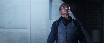 Movie still from “Everly” (2014), directed by Joe Lynch – A man standing in a room with a cigarette in his mouth; Medium shot, Low angle