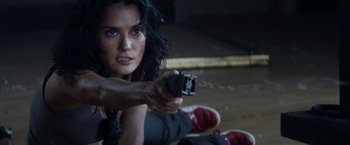 Movie still from “Everly” (2014), directed by Joe Lynch – A woman holding a gun in a room; Close Up shot, Low angle