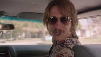 Movie still from “Everybody Wants Some!!” (2016), directed by Richard Linklater – A man with long hair and sunglasses in a car; Close Up shot, Over the shoulder angle