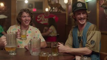 Movie still from “Everybody Wants Some!!” (2016), directed by Richard Linklater – Two people sitting at a table with a beer; Medium shot, Over the shoulder angle