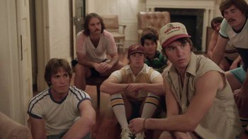 Movie still from “Everybody Wants Some!!” (2016), directed by Richard Linklater – A group of young men sitting on the floor; Medium shot, High angle