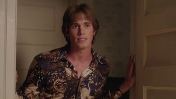 Movie still from “Everybody Wants Some!!” (2016), directed by Richard Linklater – A young man in a brown and white shirt; Medium shot, Over the shoulder angle