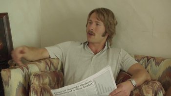 Movie still from “Everybody Wants Some!!” (2016), directed by Richard Linklater – A man sitting on a couch reading a newspaper; Close Up shot, Low angle