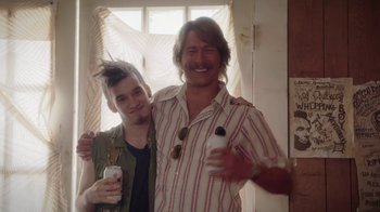 Movie still from “Everybody Wants Some!!” (2016), directed by Richard Linklater – A man standing next to another man holding a bottle; Close Up shot, Over the shoulder angle