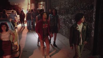 Movie still from “Everybody Wants Some!!” (2016), directed by Richard Linklater – A group of people walking down a street; Wide shot, High angle