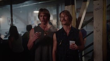 Movie still from “Everybody Wants Some!!” (2016), directed by Richard Linklater – A couple of men standing next to each other holding drinks; Medium shot, Over the shoulder angle