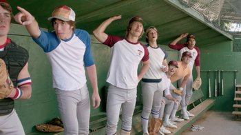 Movie still from “Everybody Wants Some!!” (2016), directed by Richard Linklater – A group of young men standing next to each other in baseball uniforms; Medium shot, High angle