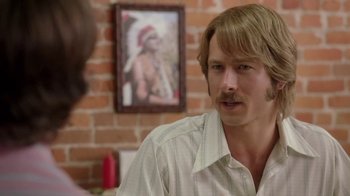 Movie still from “Everybody Wants Some!!” (2016), directed by Richard Linklater – A man with long blonde hair and a mustache is talking; Close Up shot, Over the shoulder angle