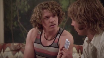 Movie still from “Everybody Wants Some!!” (2016), directed by Richard Linklater – A man holding a cell phone while talking to another man; Close Up shot, Over the shoulder angle
