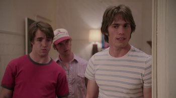 Movie still from “Everybody Wants Some!!” (2016), directed by Richard Linklater – A group of young men standing next to each other in a room; Medium shot, Over the shoulder angle