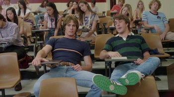 Movie still from “Everybody Wants Some!!” (2016), directed by Richard Linklater – Two young men sitting in a lecture hall; Medium shot, High angle