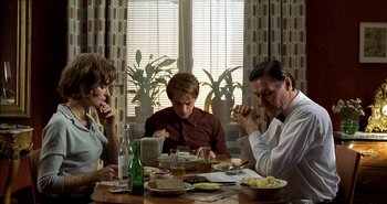 Movie still from “Evil” (2003), directed by Mikael Håfström – A group of people sitting at a table with plates of food; Medium shot, High angle