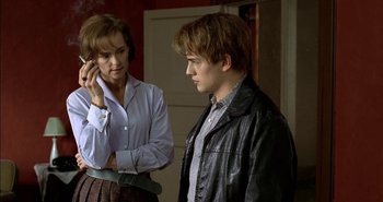 Movie still from “Evil” (2003), directed by Mikael Håfström – A man and a woman standing next to each other in a room; Medium shot, Over the shoulder angle