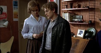Movie still from “Evil” (2003), directed by Mikael Håfström – A man and a woman standing next to each other in a room; Medium shot, Over the shoulder angle