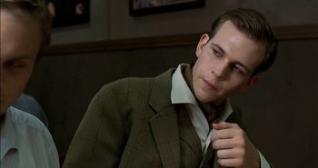 Movie still from “Evil” (2003), directed by Mikael Håfström – A man in a suit and tie looking down; Close Up shot, Over the shoulder angle