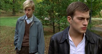 Movie still from “Evil” (2003), directed by Mikael Håfström – Two young men standing next to each other in the woods; Close Up shot, Over the shoulder angle