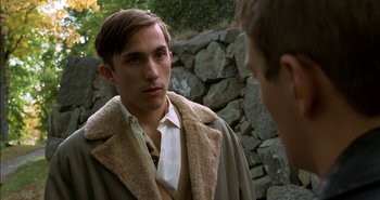 Movie still from “Evil” (2003), directed by Mikael Håfström – A young man in a brown coat is talking to another young man; Close Up shot, Over the shoulder angle
