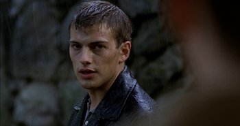 Movie still from “Evil” (2003), directed by Mikael Håfström – A man with wet hair and a black jacket; Close Up shot, Over the shoulder angle